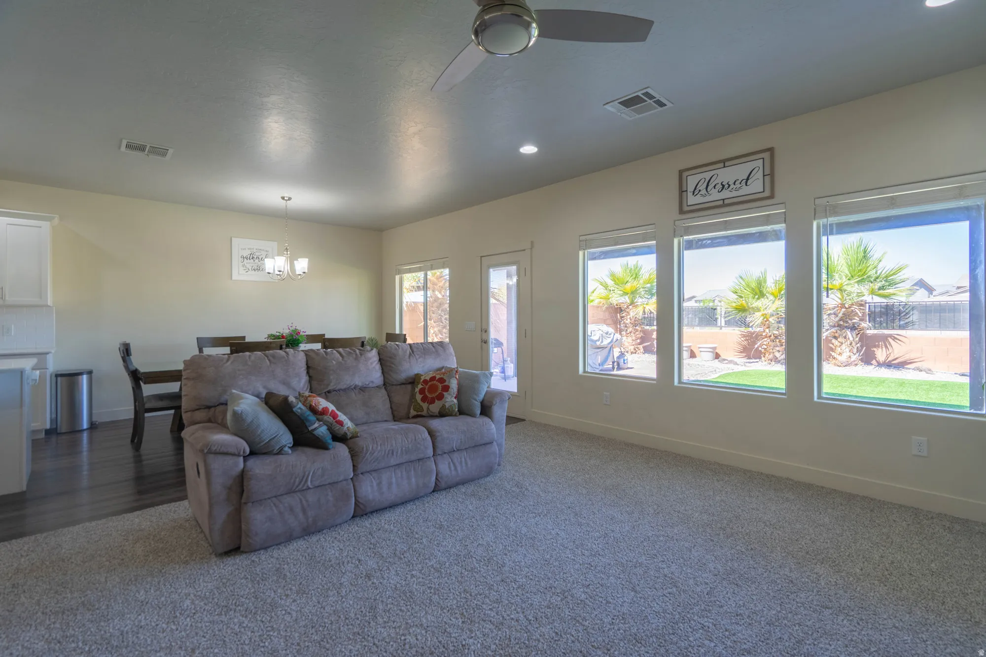 Open-concept living space featuring carpeted flooring, recessed lighting, and a ceiling fan