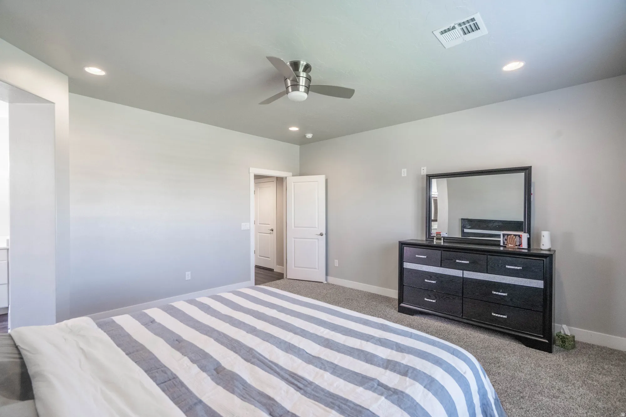 Spacious room featuring neutral carpeting and light gray wall tones