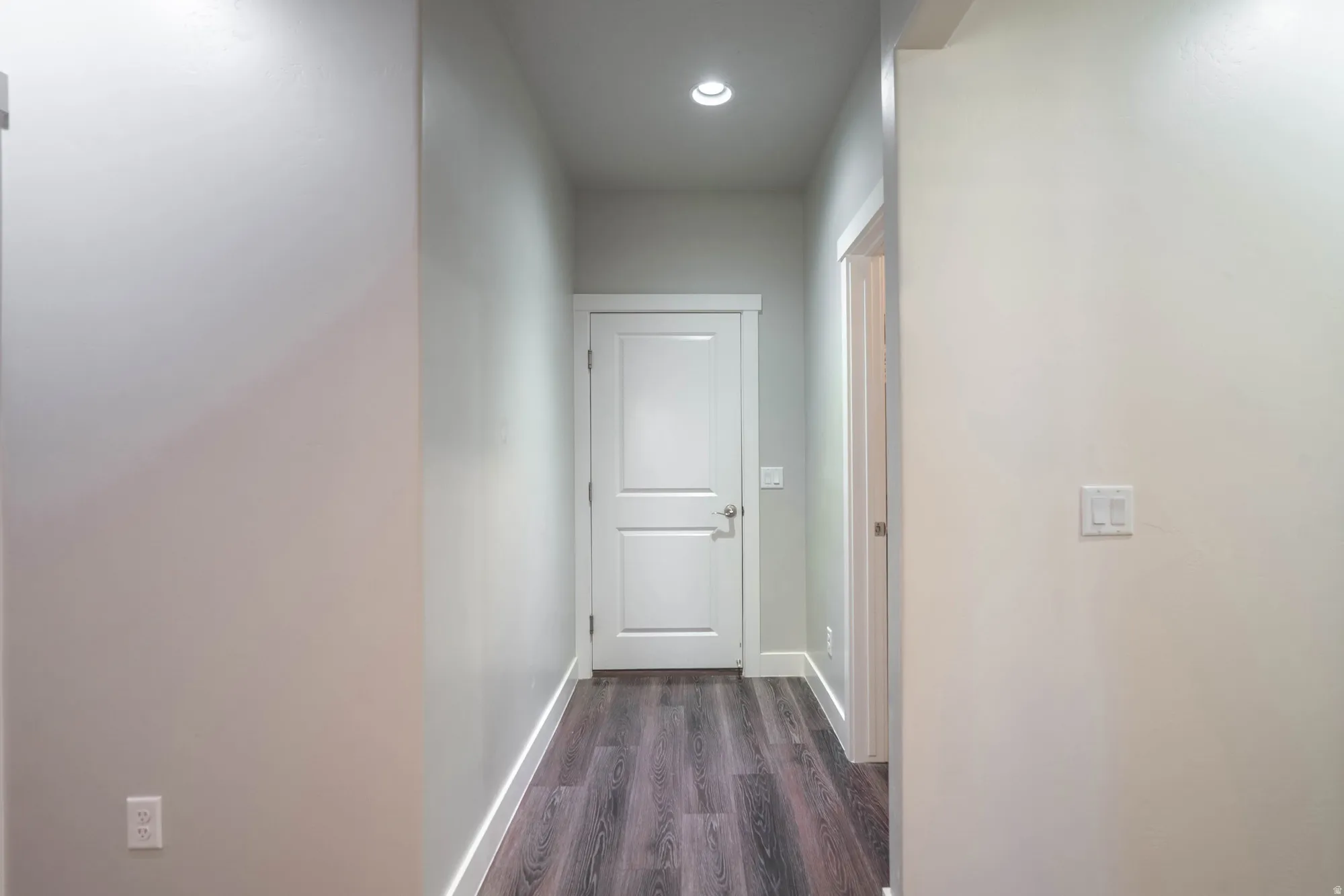 Hallway featuring recessed lighting, light-toned walls, wood-finish flooring, and white trim