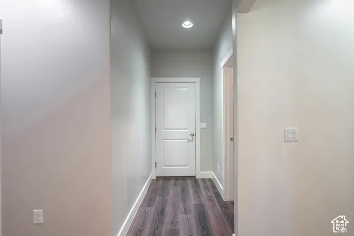 Hallway featuring recessed lighting, light-toned walls, wood-finish flooring, and white trim