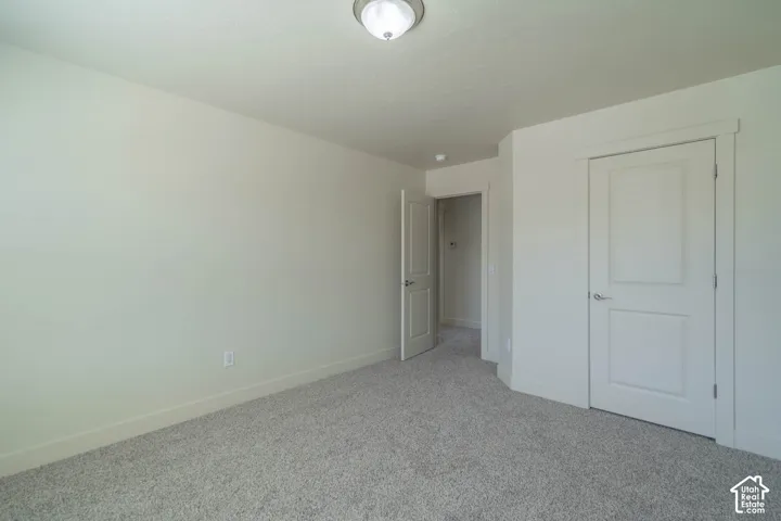 Neutral-toned room with light gray carpet flooring and white baseboards