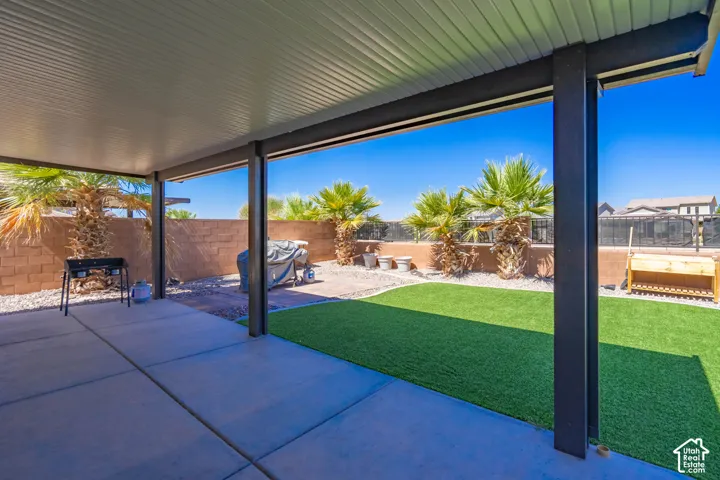 Expansive covered patio featuring concrete flooring, a solid roof, and structural support beams