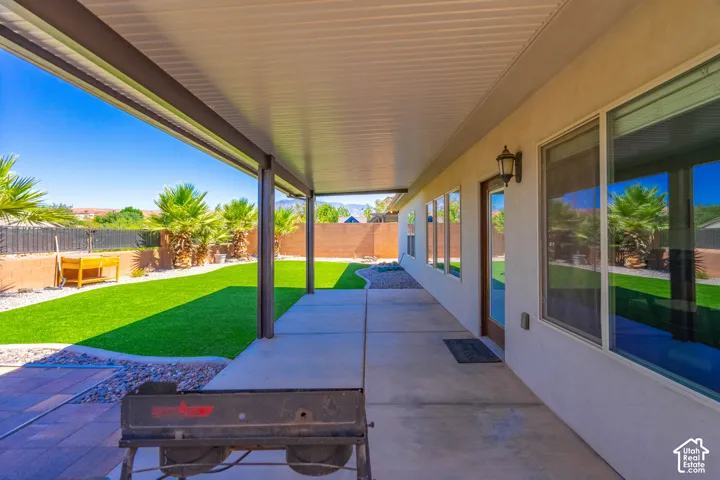 Covered patio featuring a concrete surface, multiple windows, and a glass-paneled door