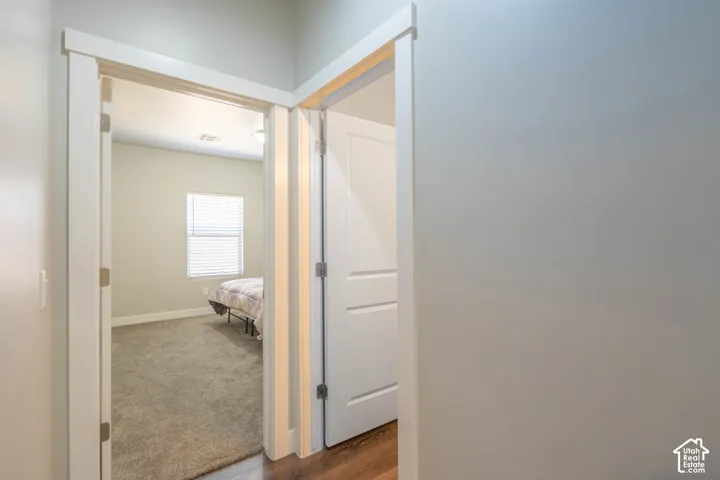 Bedroom featuring a window with horizontal blinds, neutral-toned walls, and carpet flooring
