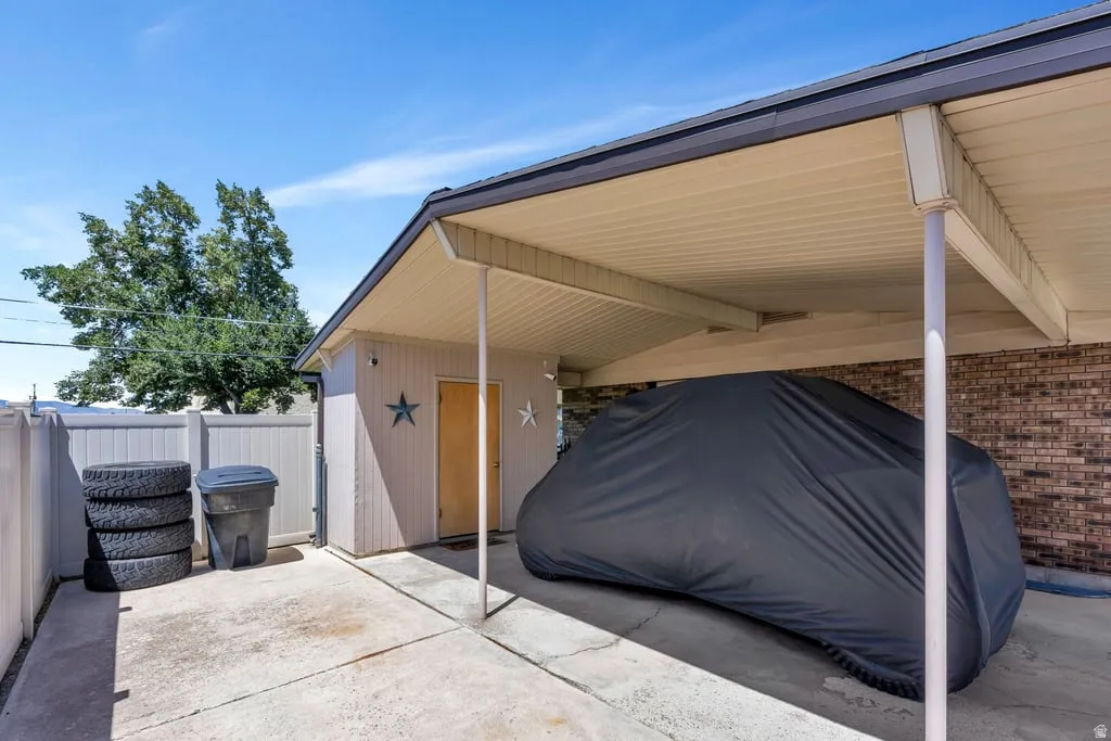 Carport featuring a concrete slab and direct access to an exterior storage shed