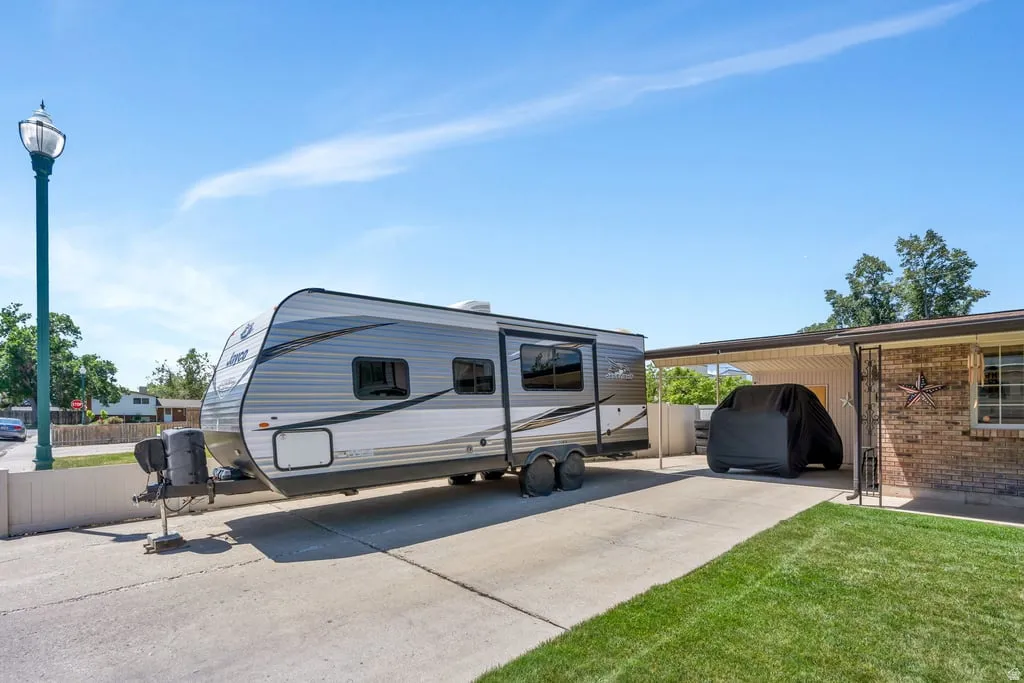 Brick exterior with a covered carport and a concrete driveway