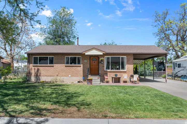 Brick exterior with a brown roof and a covered carport