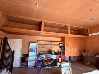 Garage featuring overhead wood-finish storage cabinets and built-in wood-finish shelving
