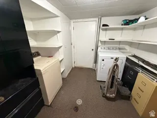 Utility area featuring built-in shelving, a washer and dryer, and carpet flooring