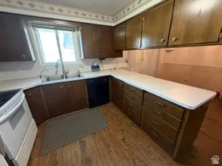 Kitchen featuring wood-finish flooring and extensive cabinetry with white countertops