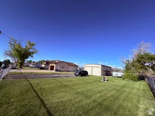 Expansive grassy yard with a chain-link fence border