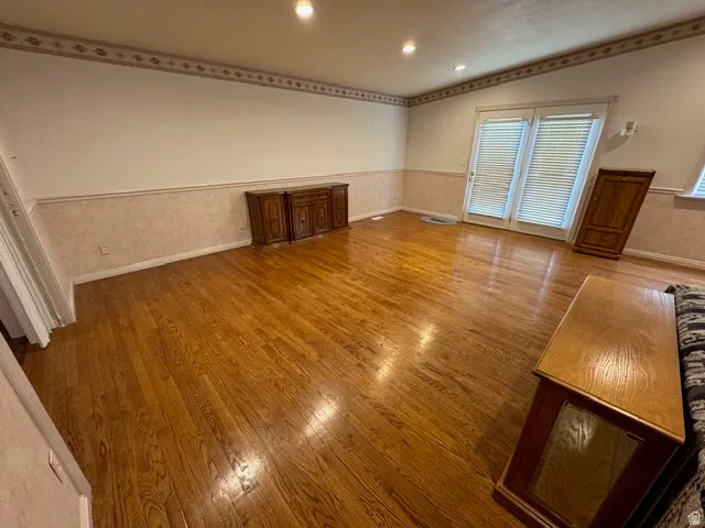 Great room featuring vaulted ceiling, hardwood flooring and recessed lighting