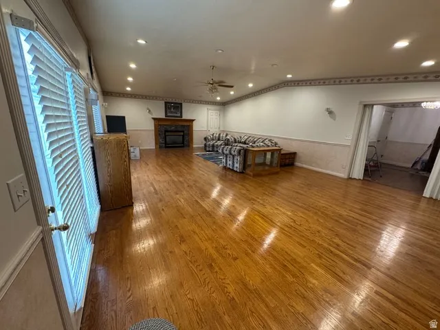 Living area featuring, wood finished floors, a glass covered fireplace, recessed lighting, and ceiling fan