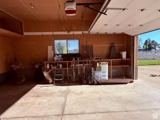 Attached two-car garage featuring a window, built-in shelving, and exposed wood paneling