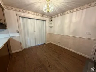 Dining area featuring wood-finish flooring, a decorative border, and chair rail molding