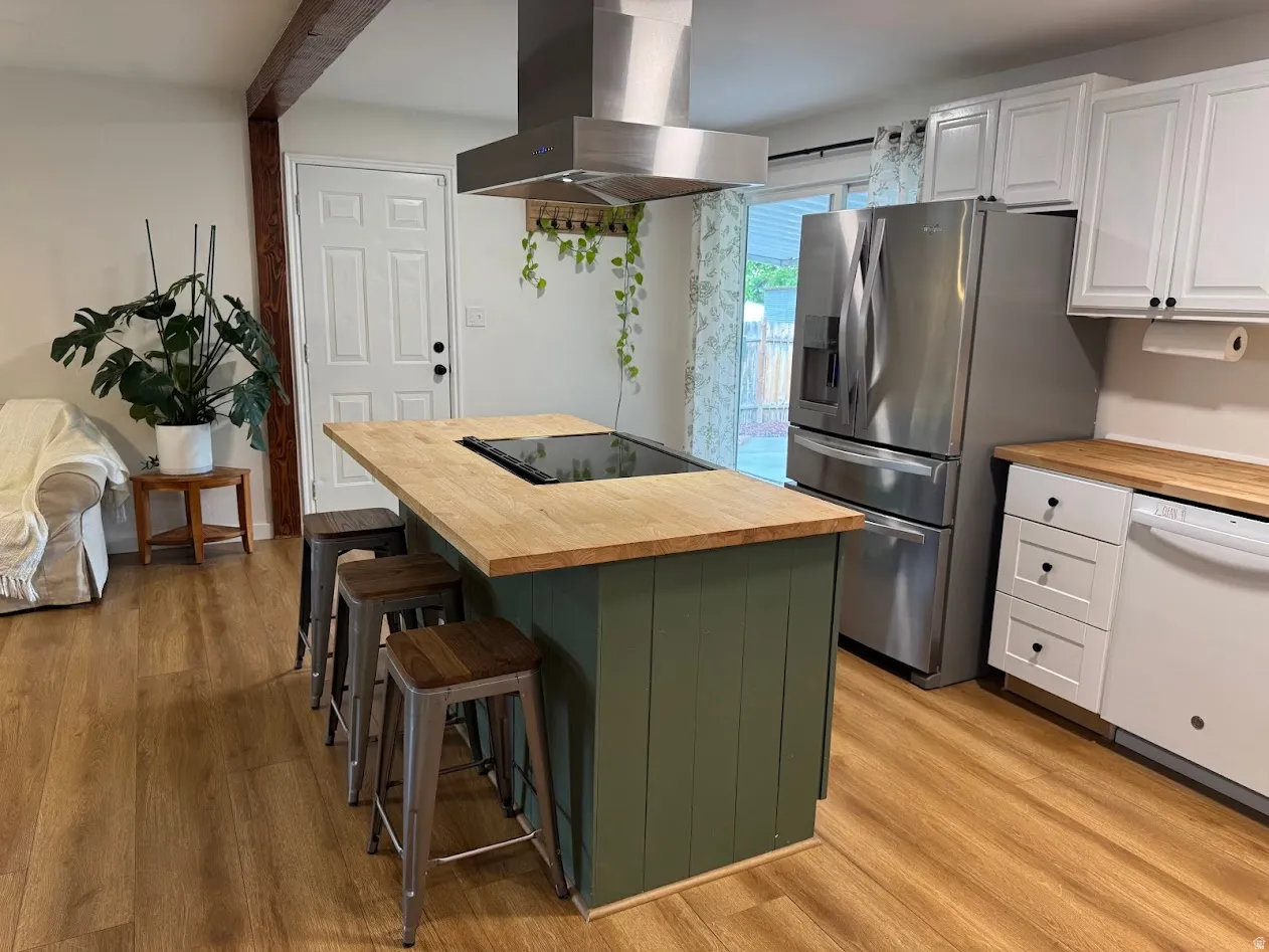 Kitchen featuring a center island with a built-in cooktop and light wood-finish countertop
