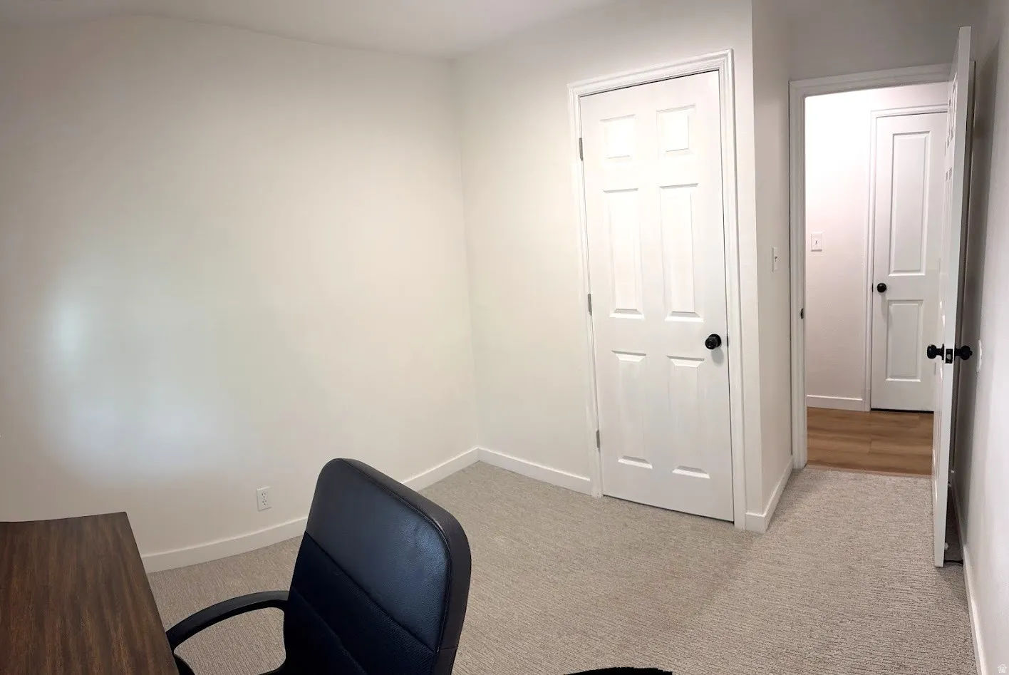 Neutral-toned carpet flooring in a room with white walls and trim