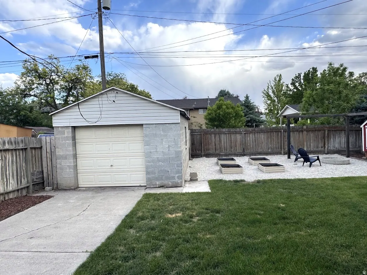 Detached garage with concrete block construction and siding, featuring a single overhead door