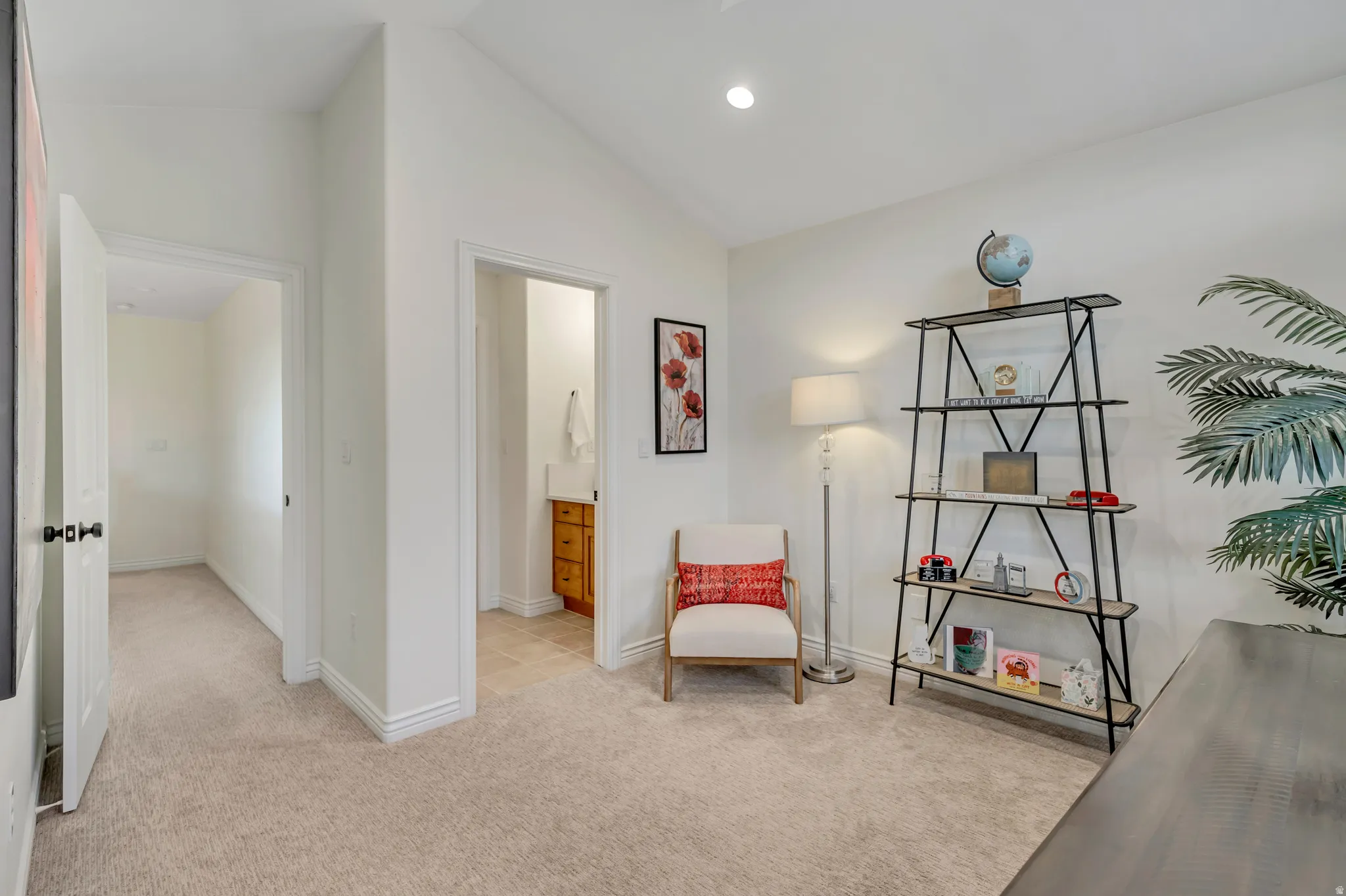 Carpeted room with recessed lighting and a doorway opening to a hallway