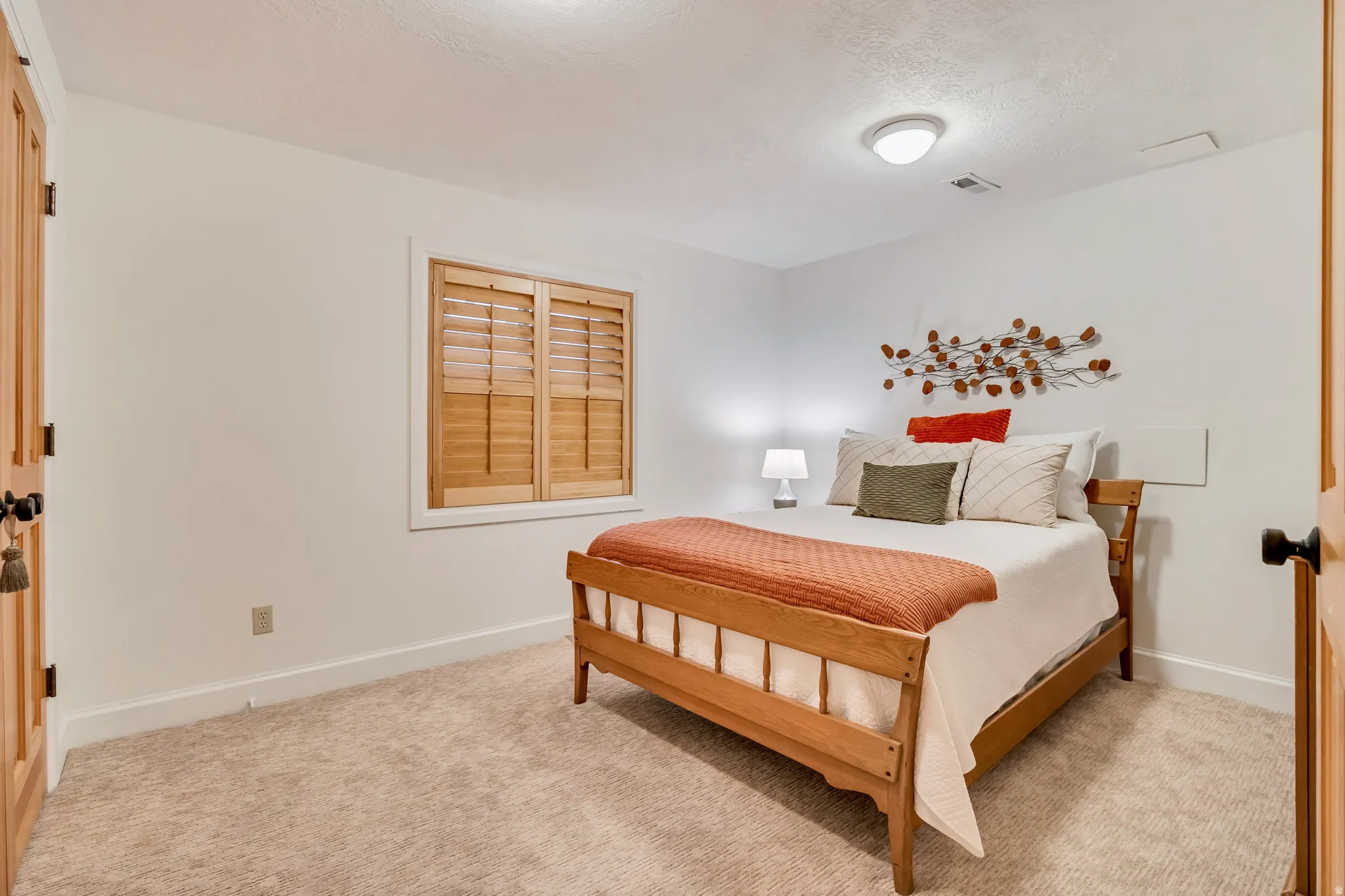 Neutral tone carpeted room with white walls and baseboards