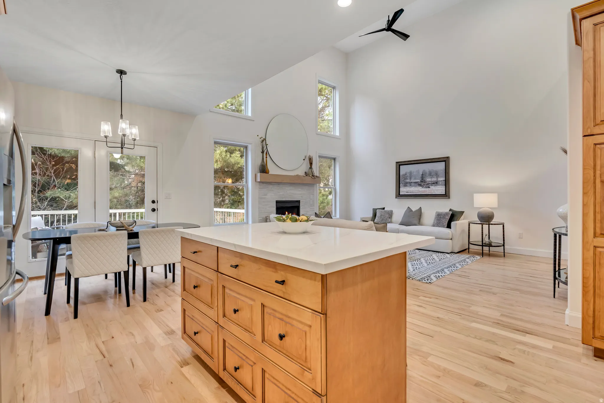 Open-concept living space featuring a central kitchen island with wood cabinetry and a light-colored countertop