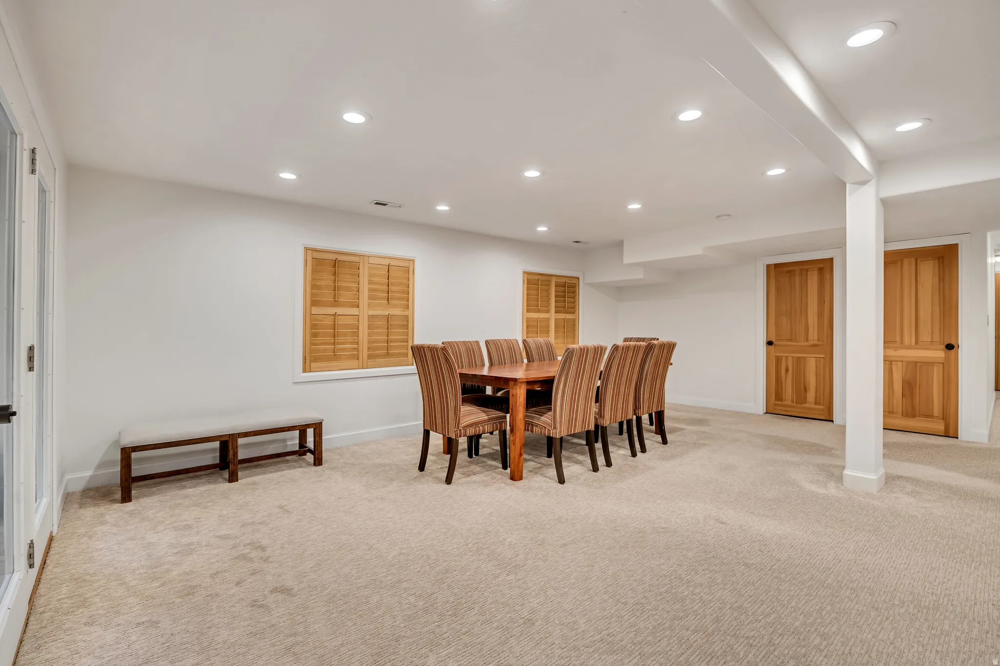 Spacious room featuring neutral carpeting, recessed lighting, and white walls