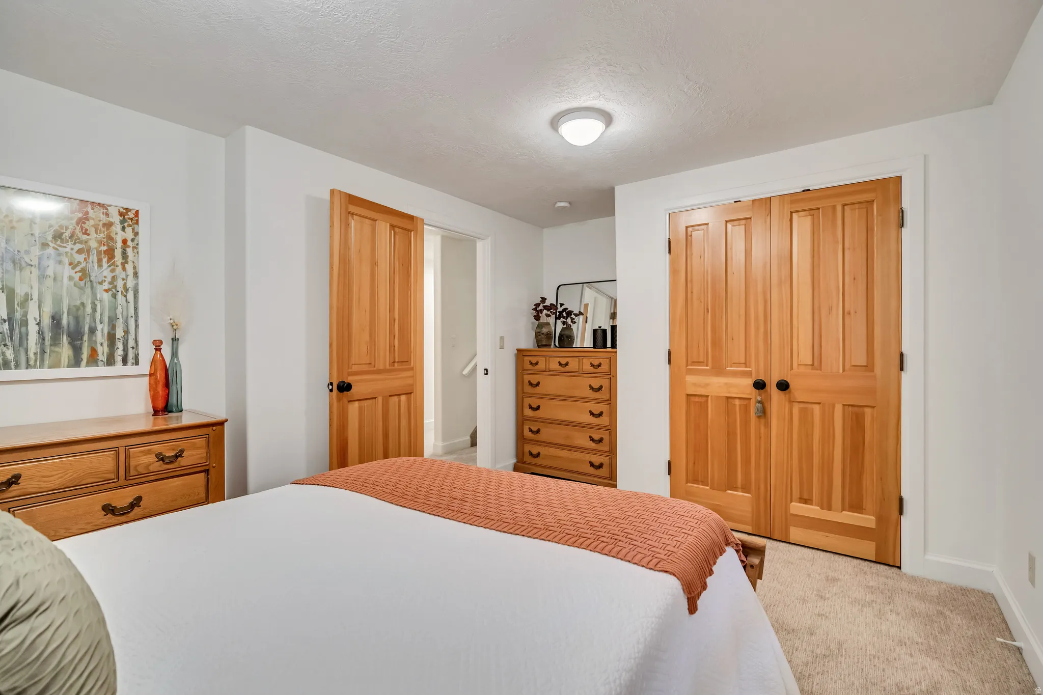 Warm wood-finish double doors and a single panel door provide entry points within this room