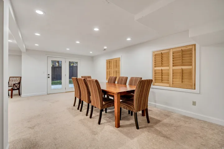 Carpeted room with recessed lighting and double glass-paneled doors