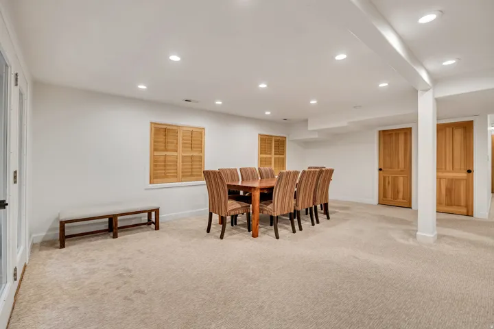Spacious room featuring neutral carpeting, recessed lighting, and white walls