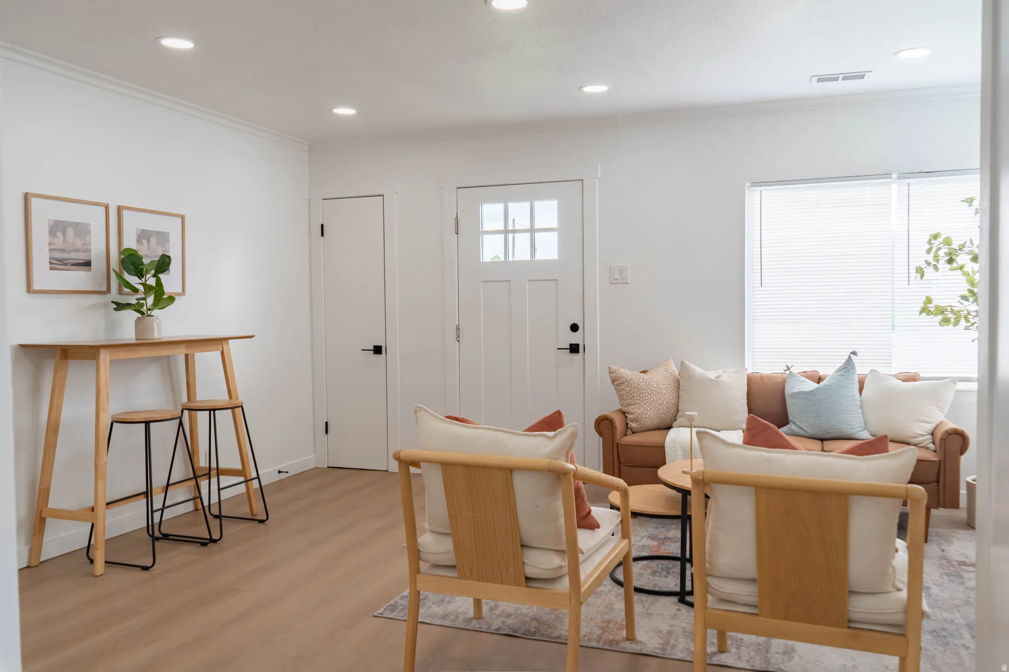 Bright living space featuring wood-finish flooring, recessed lighting, and white baseboards