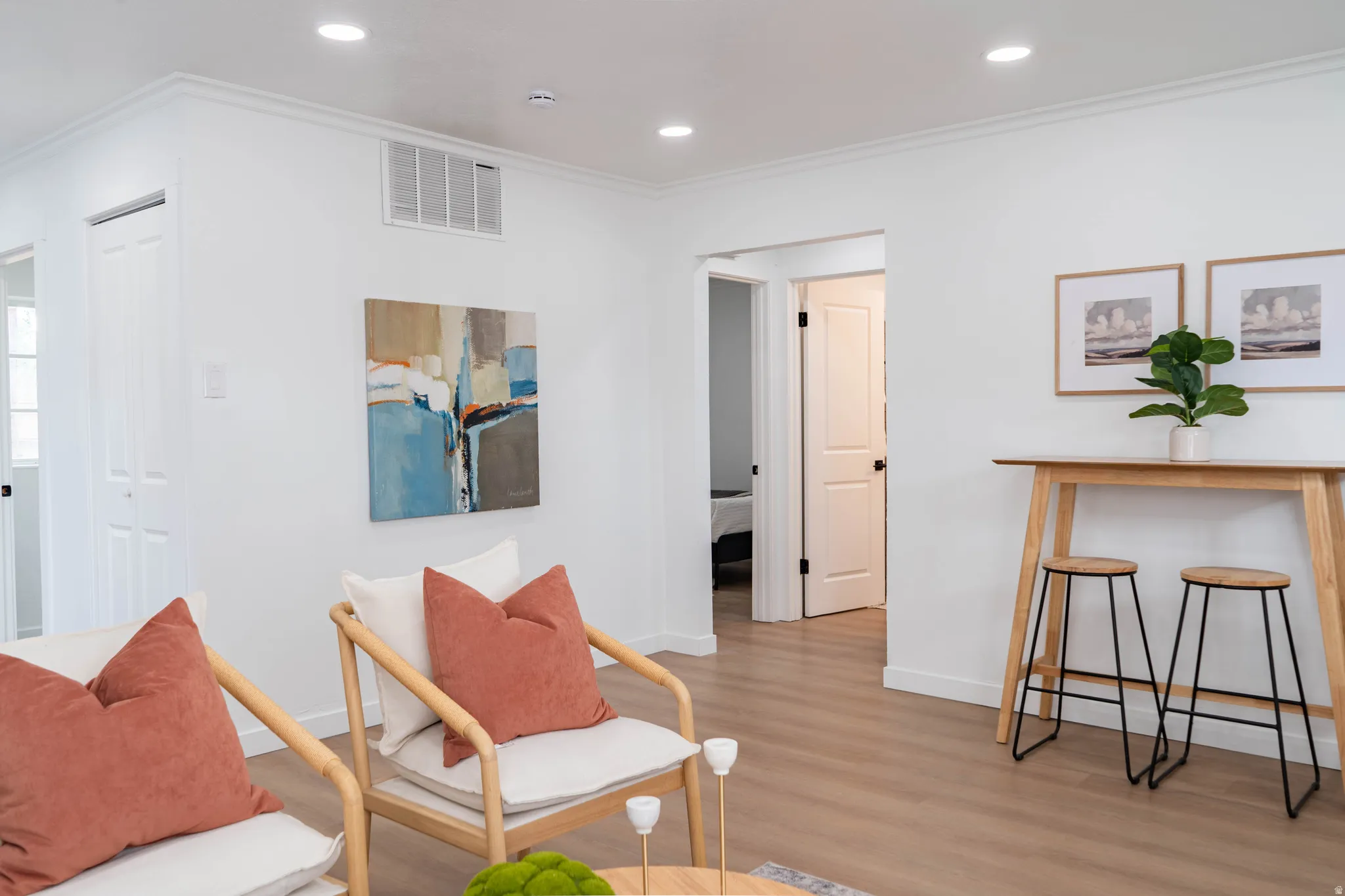 Bright interior featuring recessed lighting, crown molding, wood-finish flooring, and crisp white walls