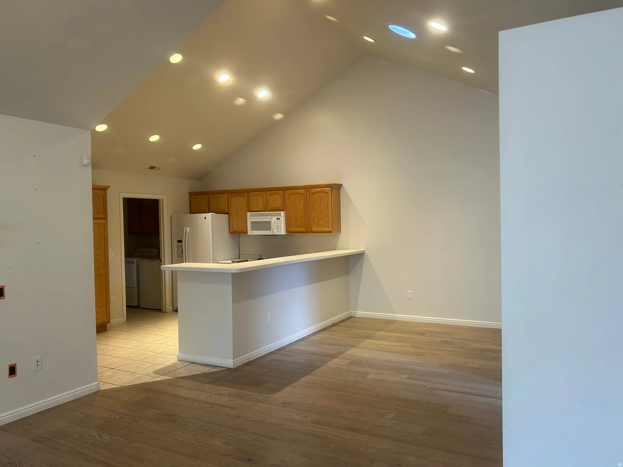 Open-concept living space with vaulted ceilings and recessed lighting