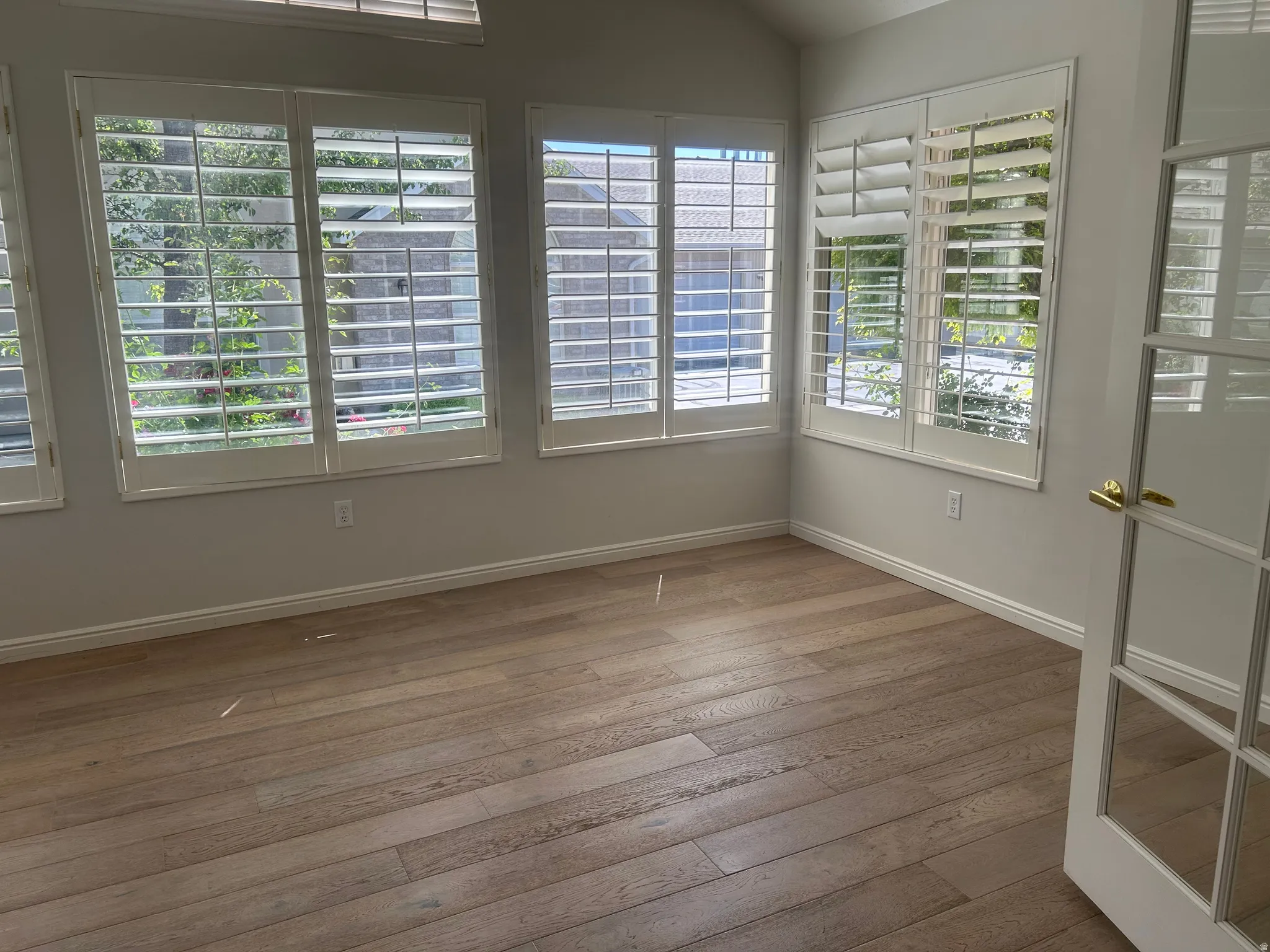 Room featuring wood-finish flooring, white baseboards, and neutral wall paint