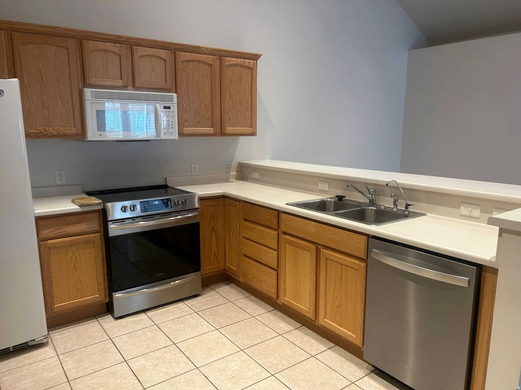 Kitchen featuring wood cabinetry, light-toned countertops, and a tiled floor