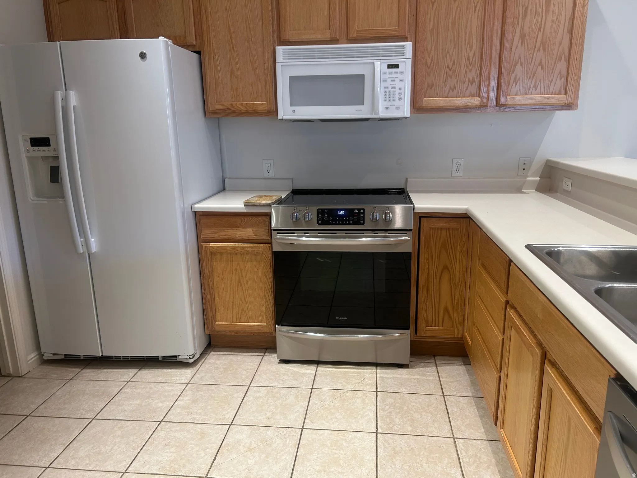 Kitchen featuring light wood cabinetry, light-toned countertops, and square tile flooring