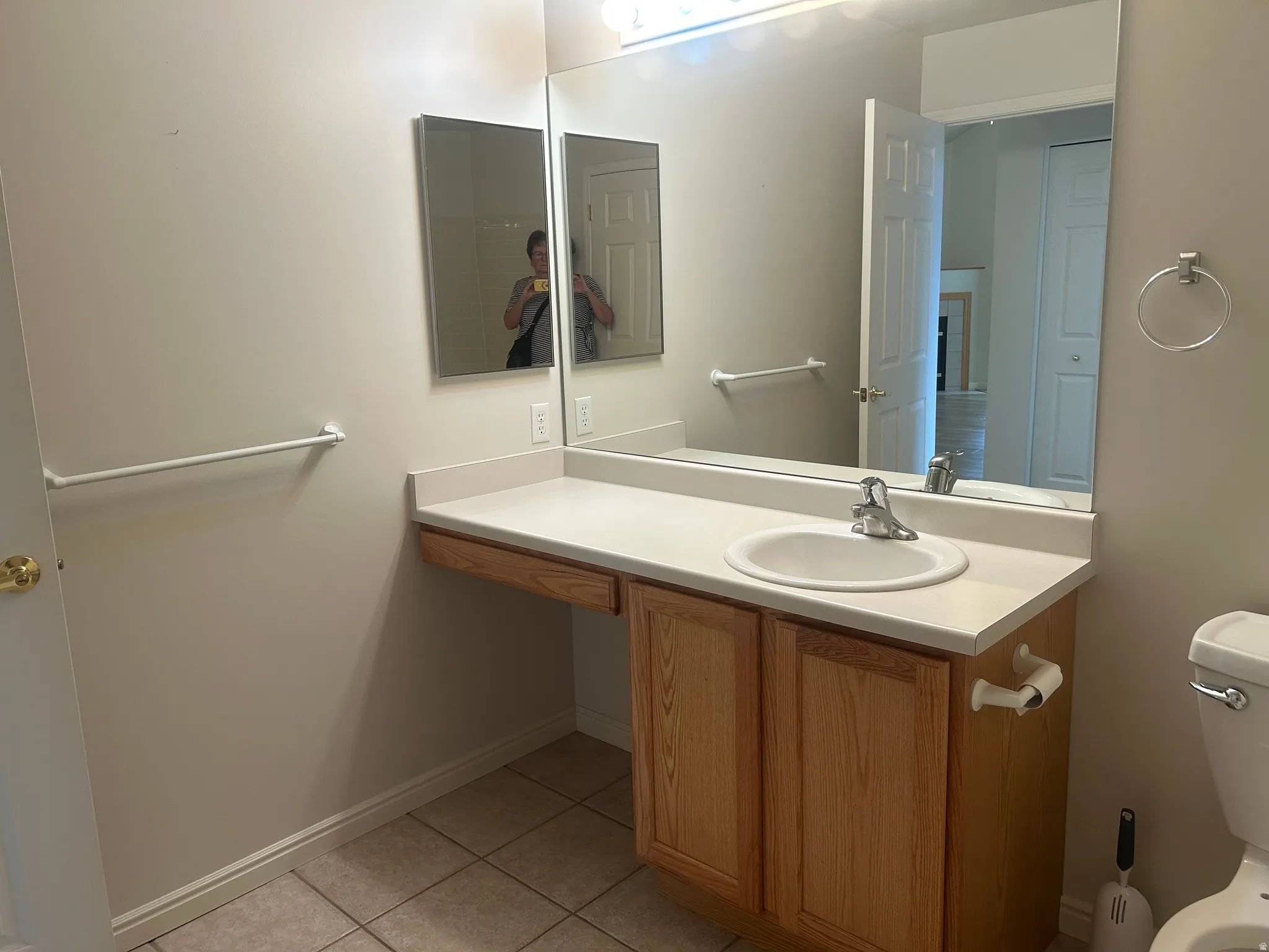 Bathroom vanity featuring an integrated sink, light-toned countertop, and wood-finish cabinetry