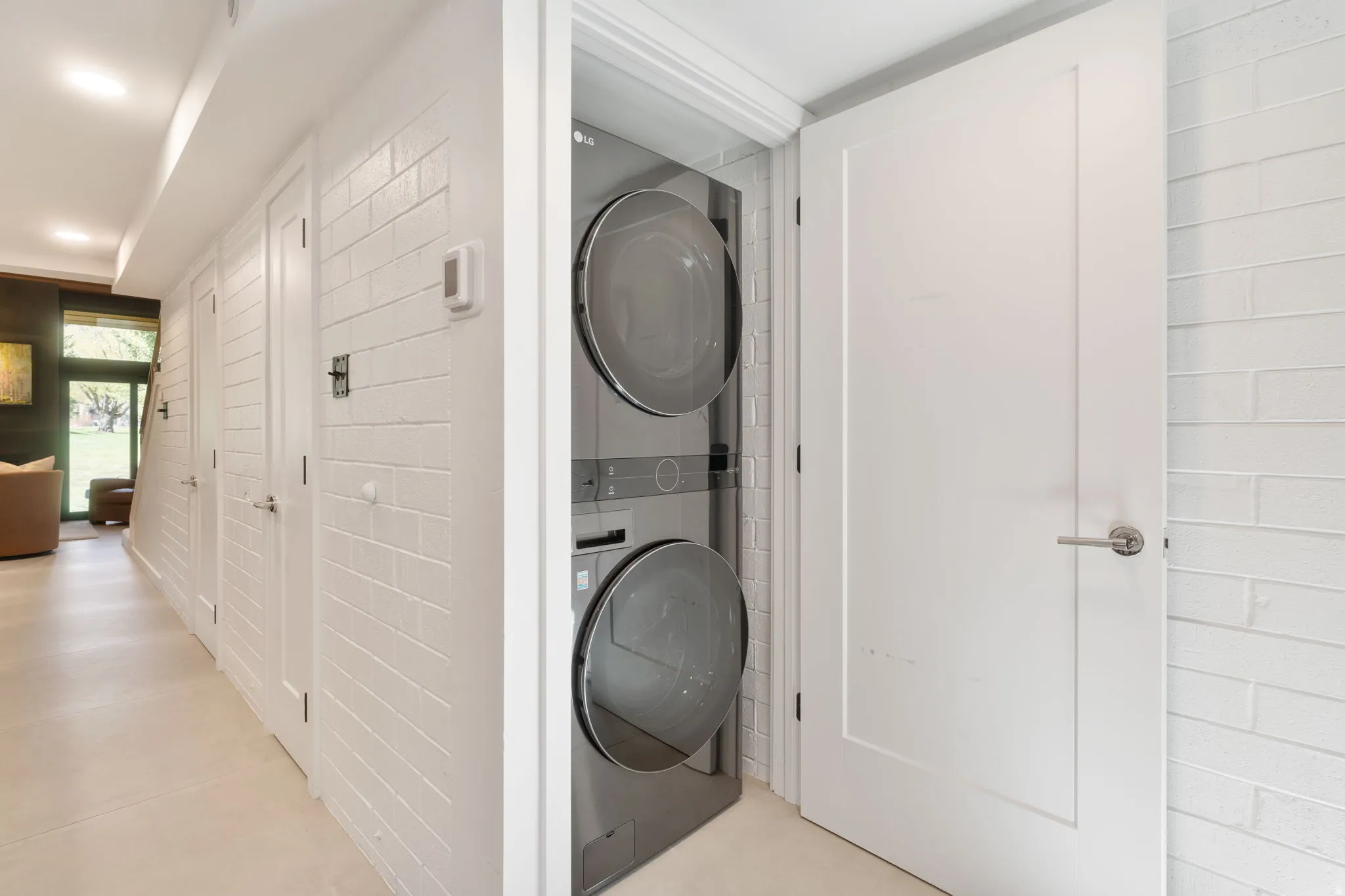 Dedicated laundry alcove featuring a stacked washer and dryer unit