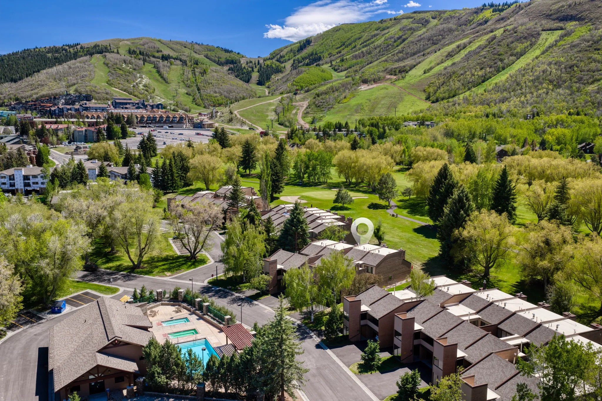 Aerial perspective showcasing residential buildings amidst verdant landscaping and mountainous terrain