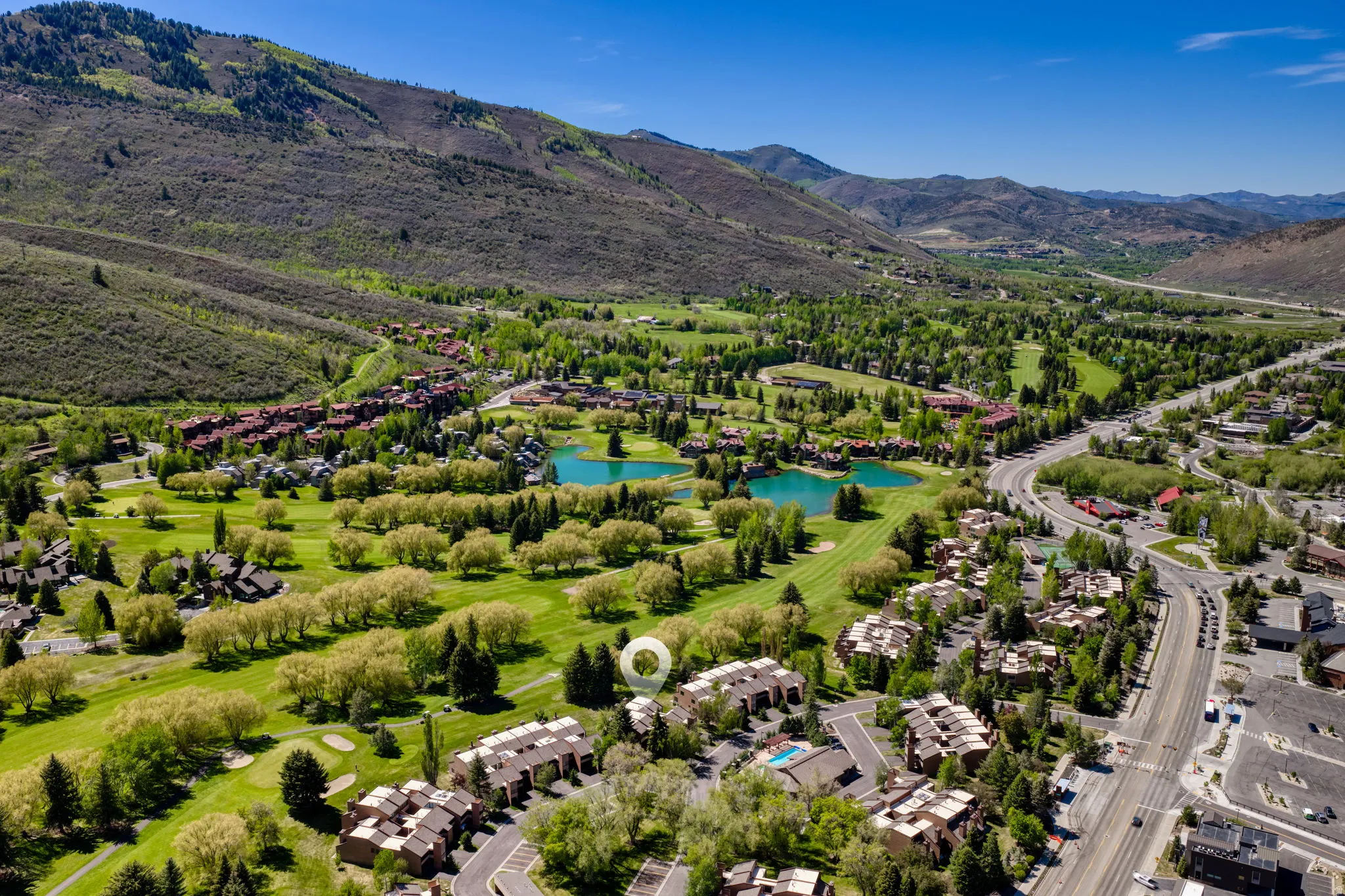 Aerial perspective highlighting the property's setting amidst a golf course and mountainous terrain