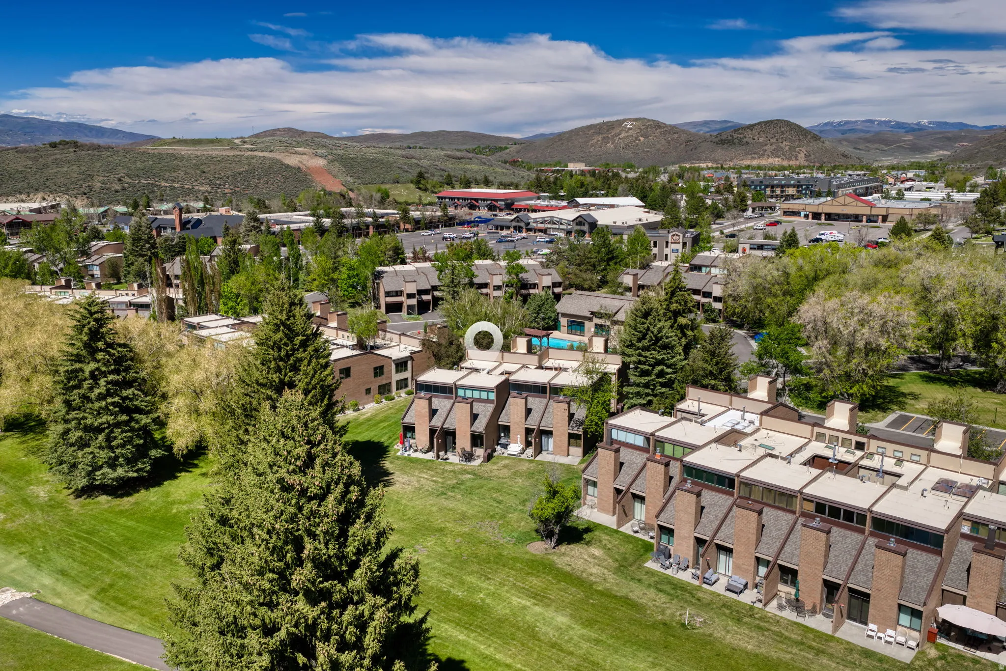 Terraced townhome-style residences with private patios and a surrounding green space