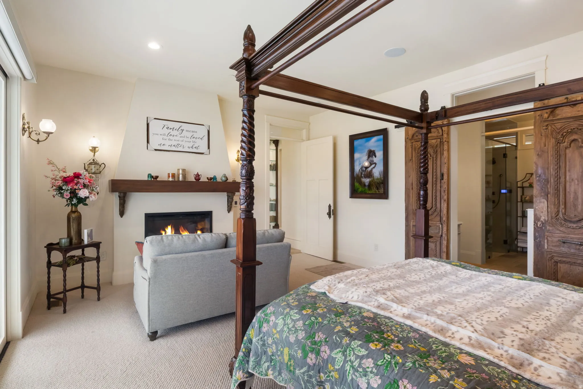 Spacious room featuring a fireplace with a wood mantel, light-toned walls, and soft carpeting