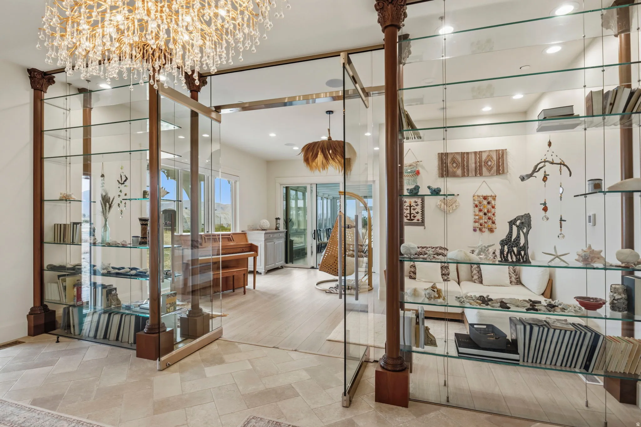 Spacious interior featuring a decorative crystal chandelier and glass display shelving with wood accents