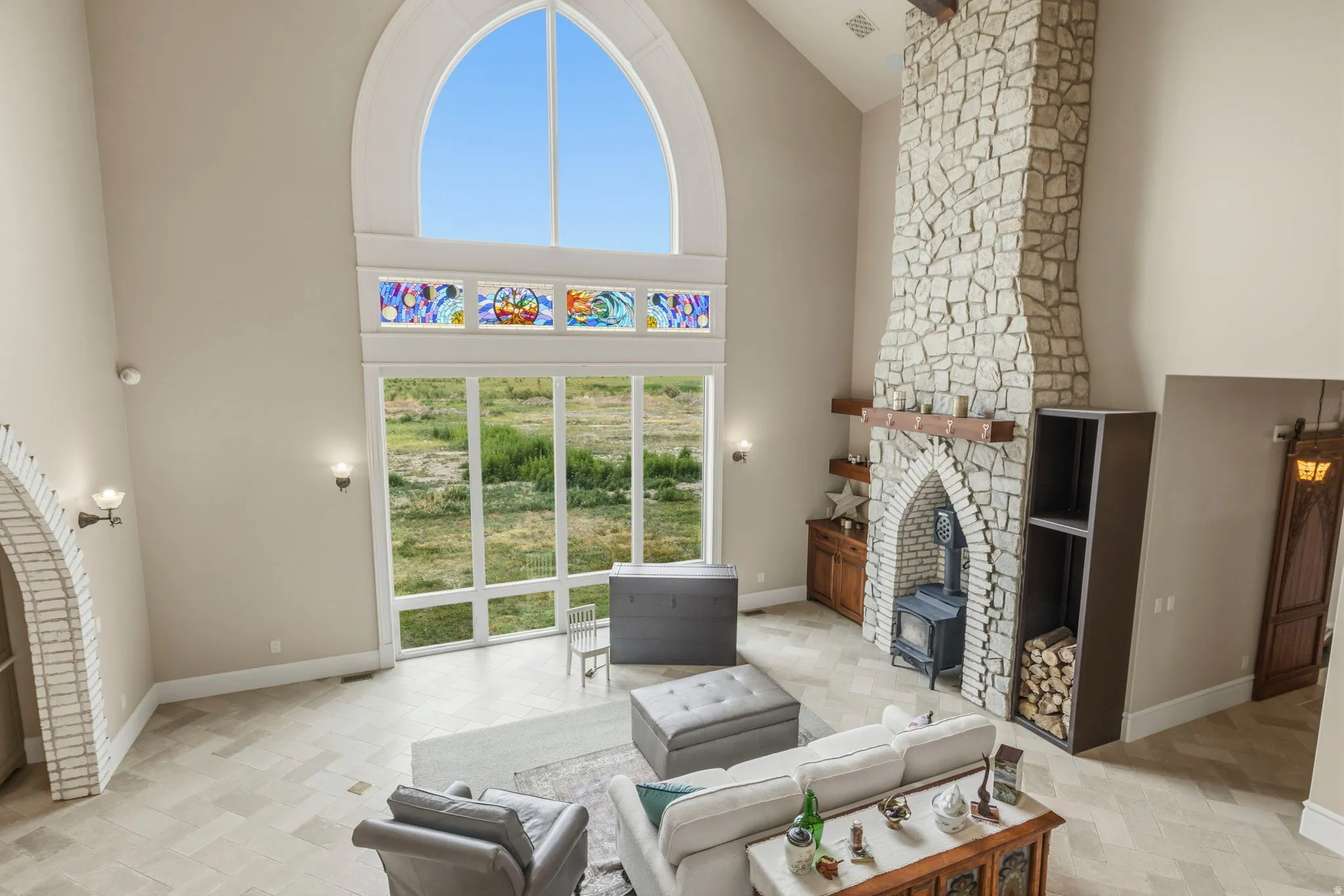 Two-story living area featuring a vaulted ceiling and a stone fireplace