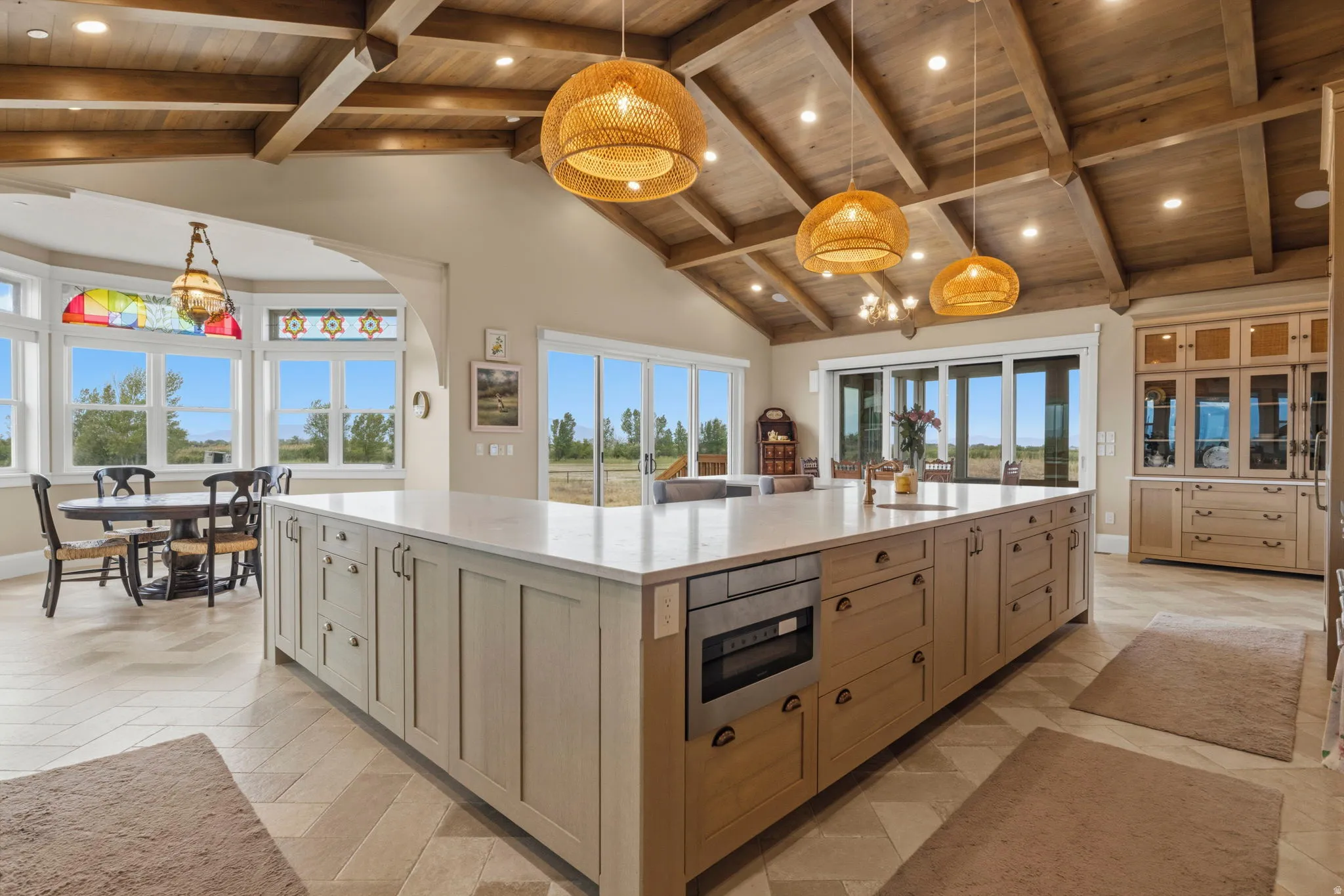 Spacious kitchen featuring a large central island with light-toned cabinetry, a built-in microwave, and integrated sink