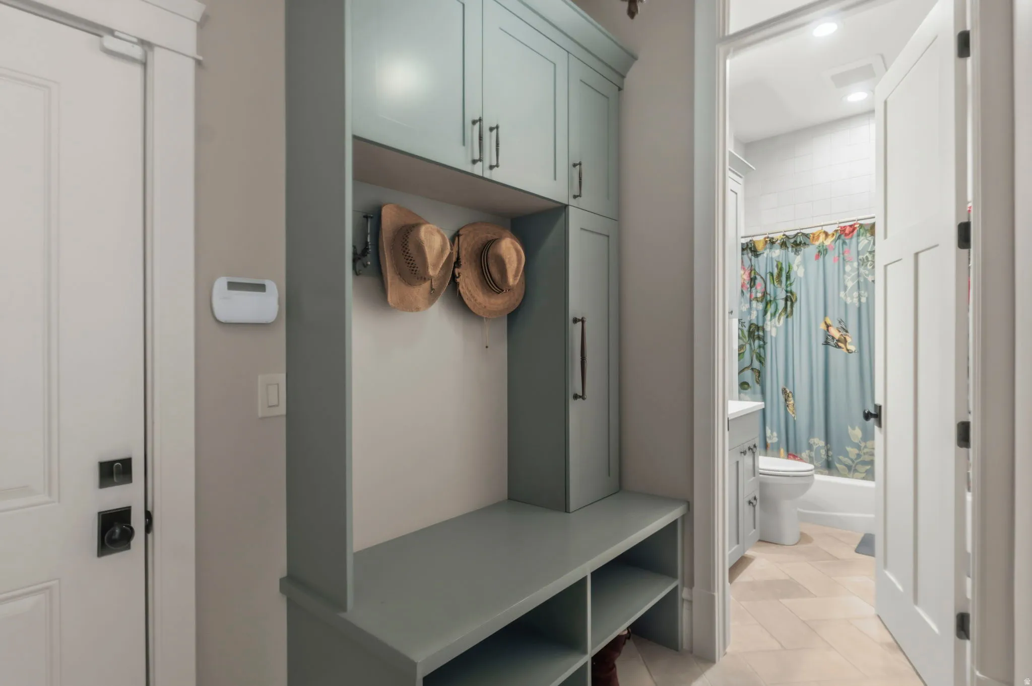 Custom built-in entryway storage right off the garage with shelving and upper cabinetry