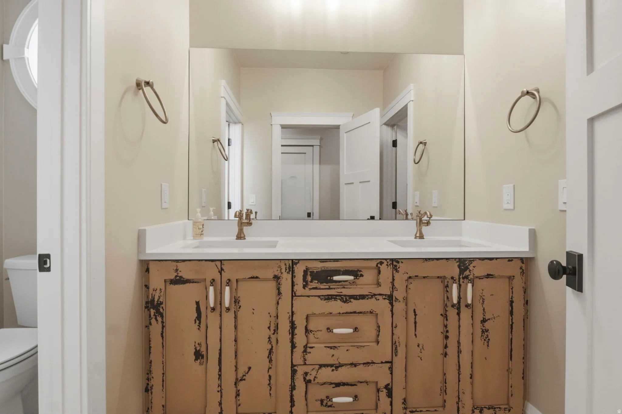 Double vanity featuring a distressed wood-finish cabinet with white countertops