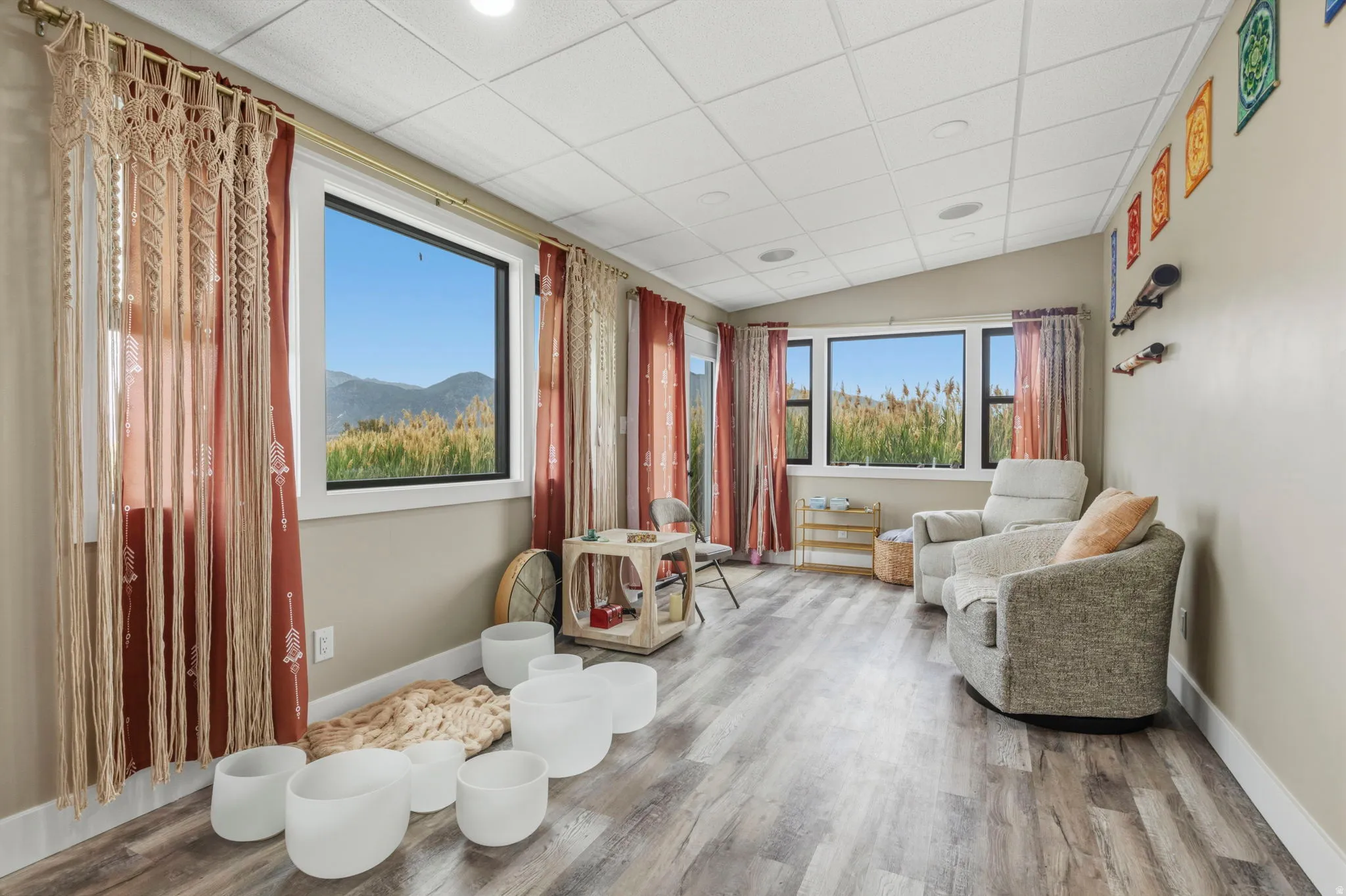 Bright Yoga Studio room off the RV garage featuring wood-finish flooring, multiple windows, a sloped ceiling with recessed lighting, and a neutral wall color