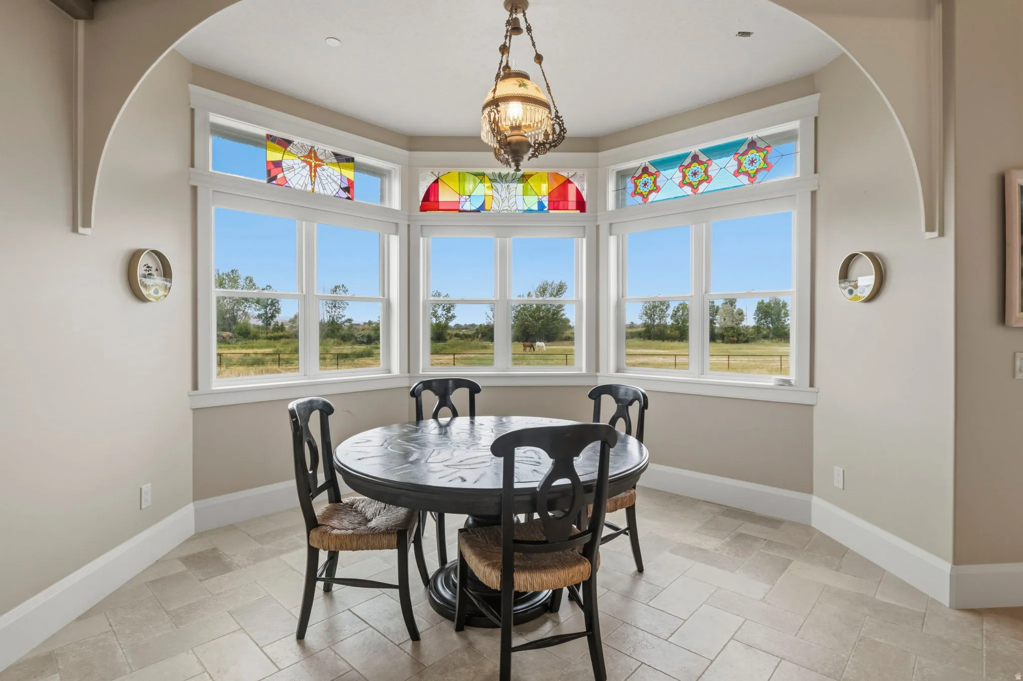 Bay window with stained glass transoms and white trim surround this extra breakfast nook
