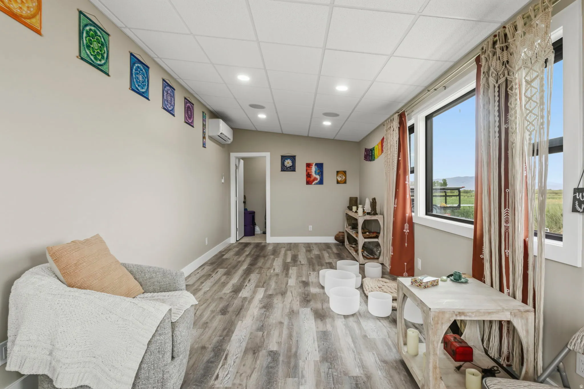 Spacious gym/yoga studio featuring wood-finish flooring, recessed lighting, and a window framing an outdoor landscape