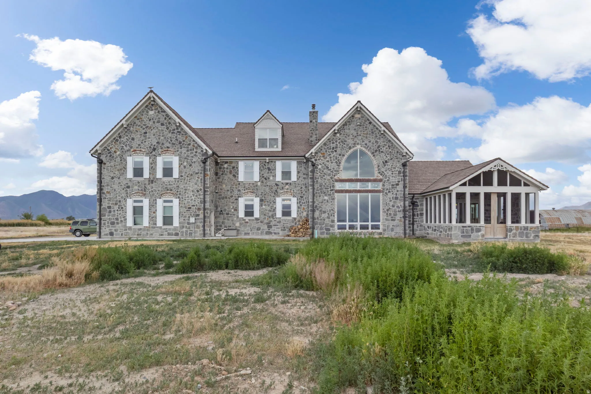 Stone exterior residence with multiple gables and a dormer